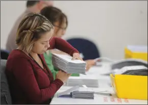  ??  ?? Jessica Lang inspects ballots at the Registrar of Voters in Stockton on Thursday.