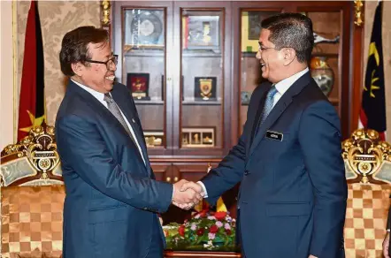  ??  ?? Welcome to Sarawak: Azmin (right) shaking hands with Abang Johari during a courtesy call at the Sarawak Legislativ­e Assembly in Kuching.