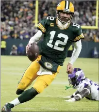  ?? MORRY GASH — THE ASSOCIATED PRESS ?? Green Bay Packers quarterbac­k Aaron Rodgers, left, sprints past Minnesota Vikings linebacker Brian Asamoah II, for a two-yard touchdown run during the Packers’ win Sunday. Green Bay can clinch a playoff berth by beating the Detroit Lions this Sunday.