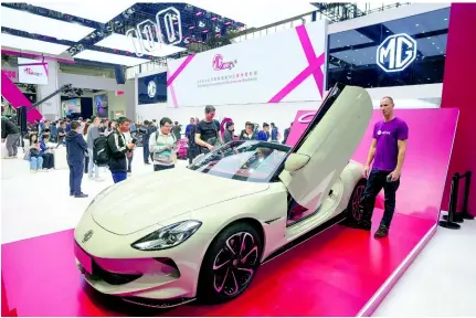  ?? AP ?? Visitors look at an MG car during the opening of China Auto Show in Beijing, China, on Thursday, April 25, 2024.