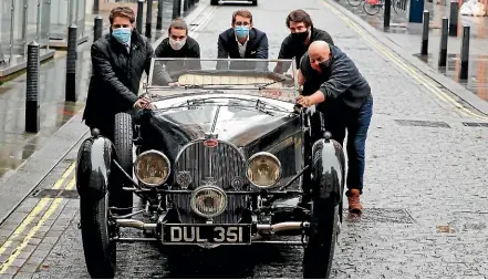  ?? AP ?? Bill Turnbull’s 1937 Bugatti Type 57S is pushed by staff outside Bonhams auction house in London.