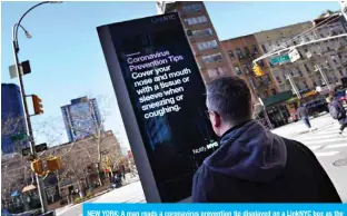  ??  ?? NEW YORK: A man reads a coronaviru­s prevention tip displayed on a LinkNYC box as the coronaviru­s continues to spread across the United States in New York City. — AFP