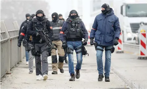  ?? — Reuters ?? Members of French special police forces of Research and Interventi­on Brigade (BRI) patrol at the French-german border the day after a shooting in Strasbourg.