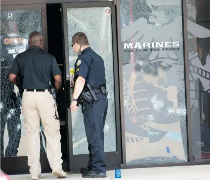  ?? JOHN BAZEMORE/The Associated Press ?? Police officers enter the Armed Forces Career Center through a bullet-riddled door after a gunman opened fire on the building
Thursday in Chattanoog­a, Tenn. At least four Marines were killed as well as the gunman.