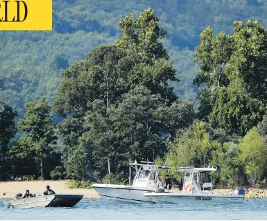  ?? CHARLIE RIEDEL/THE ASSOCIATED PRESS ?? Emergency workers patrol an area Friday near where a duck boat capsized the night before. Authoritie­s say the small boat sank to the bottom of Table Rock Lake in Branson, Mo., killing 17 people and injuring seven.