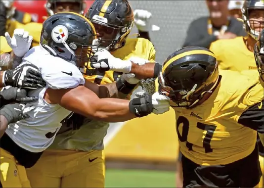  ?? Matt Freed/Post-Gazette ?? Steelers center Kendrick Green and defensive tackle Cam Heyward grab each others facemarks in training camp Aug. 2 at Heinz Field. Green appears to be in line to start at center this year.