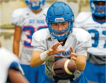  ?? STAFF PHOTO BY C.B. SCHMELTER ?? Red Bank’s Maddox Wilkey takes the snap during practice at Red Bank High School on Monday.