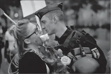  ?? AP/EMILIO MORENATTI ?? A woman kisses a French police officer after giving him flowers Saturday near the Eiffel Tower in Paris during a demonstrat­ion of support for French security forces on guard for the election.