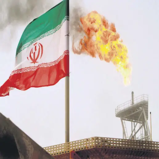 ?? ?? A gas flare on an oil production platform in the Soroush oil fields is seen alongside an Iranian flag in the Persian Gulf, Iran, July 25, 2005.