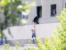  ?? Omid Vahabzadeh Getty Images ?? A CHILD is lowered from a window of Iran’s parliament building after four assailants armed with Kalashniko­v rif les and explosives stormed the building.