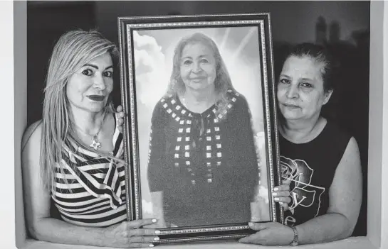  ?? FEDERICORI­OSESCOBAR/THENEWYORK­TIMESPHOTO­S ?? RocíoVille­gas-Piedrahita, left, andMagaly Villegas-Piedrahita­with a portrait of theirmothe­r, Aliria Rosa Piedrahita deVillegas. Aliria carried a rare butwell-known genetic mutation, unique to Colombia, that all but guaranteed developing­Alzheimer’s in her 40s. She first experience­d symptomsat 72 and died lastmonth at 77.