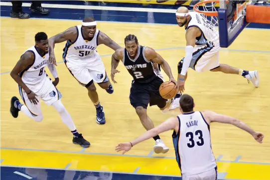  ??  ?? San Antonio Spurs forward Kawhi Leonard (2) drives to the basket between Memphis Grizzlies forward James Ennis (8), forward Zach Randolph (50), guard Vince Carter (15), and center Marc Gasol (33) during the second half of Game 6 in an NBA basketball...