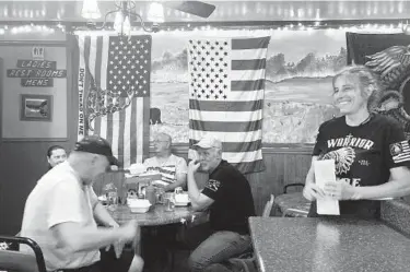  ?? MICHAEL KUNZELMAN/AP ?? Pauline Bauer, right, speaks with customers last month at Bauer’s restaurant, Bob’s Trading Post, in Hamilton, Pa. Bauer is one of more than 500 people charged with federal crimes stemming from the Jan. 6 riot at the U.S. Capitol.