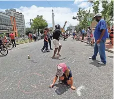  ?? GERALD HERBERT, AP ?? Roscoe Adair, 6, draws a heart with chalk in the street as workers prepare to take down the statue of former Confederat­e Gen. Robert E. Lee in New Orleans on May 19.