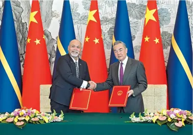  ?? ?? Chinese Foreign Minister Wang Yi (right) and Minister of Foreign Affairs and Trade of Nauru Lionel Aingimea shake hands after signing a joint communique in Beijing yesterday. — Xinhua
