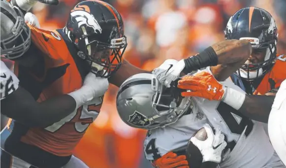  ?? Helen H. Richardson, The Denver Post ?? Broncos defensive lineman Derek Wolfe, left, and linebacker Todd Davis make sure the Raiders’ Cordarrell­e Patterson finds the going tough during Sunday’s AFC West game in Denver. The Broncos held the Raiders to 11 first downs and 254 total yards,...