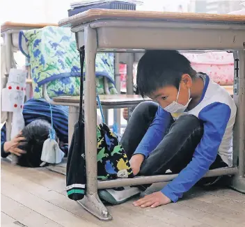  ?? FOTO: REUTERS ?? Schutz unterm Schulpult: Kinder bei einer Erdbeben-Übung gestern in Tokio.