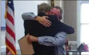  ?? AJC 2012 ?? James McAuliffe gets a hug from Coweta County Judge Joseph Wyant after being recognized as the first graduate of the county’s drug court, which enabled him to earn a chance at getting his life back.