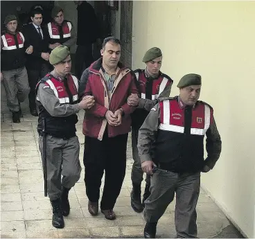  ?? AP PHOTO ?? Turkish paramilita­ry police officers escort Syrian smugglers Muwafaka Alabash, front,
and Asem Alfrhad, rear, to their trial in Bodrum, Turkey, on Friday.