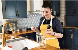  ?? CYDNI ELLEDGE/THE NEW YORK TIMES ?? Author Lindsay-Jean Hard cooks with bananas May 5 in Ann Arbor, Michigan. Hard is an expert on no-waste cuisine and wrote a book about cooking with scraps.