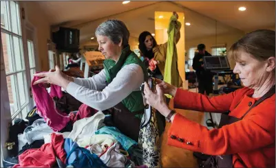  ?? Amanda Voisard/For the Washington Post ?? Above, Lucie Holland, from left, Amy O’Donnell and Marian Bishop look through exercise clothing during an estate sale at the home of fitness guru Denise Austin on April 29, 2014. Below,