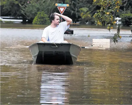  ?? STUART VILLANUEVA/THE GALVESTON COUNTY DAILY NEWS ?? Tyler Burris rows along a flooded section of Independen­ce Drive on Thursday in Friendswoo­d, Texas.