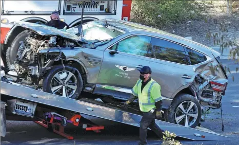  ?? REUTERS ?? The SUV of Tiger Woods is loaded onto a recovery truck after being involved in a single-vehicle accident in Los Angeles, California, on Tuesday. The American golf great was rushed to hospital after sustaining severe injuries to his legs.