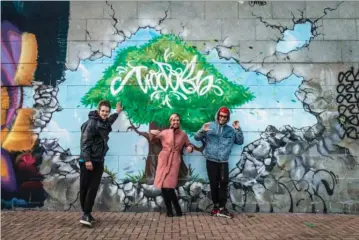  ??  ?? Streetkuns­tnerne Nikita Rufas, Anfisa Kochneva og Denis Blago foran deres vaerk i Jekaterinb­urg. Foto: Anne Hollande/Hans Lucas