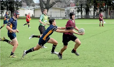 ?? PHOTO: LAWRENCE GULLERY ?? Matamata College Under 15s rugby player John Couch manages to get away from a Hillcrest High School tackler.