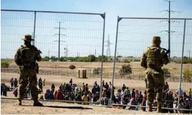  ?? Photograph: Andres Leighton/AP ?? Migrants wait in line adjacent to the border fence to enter into El Paso, Texas, on 10 May.