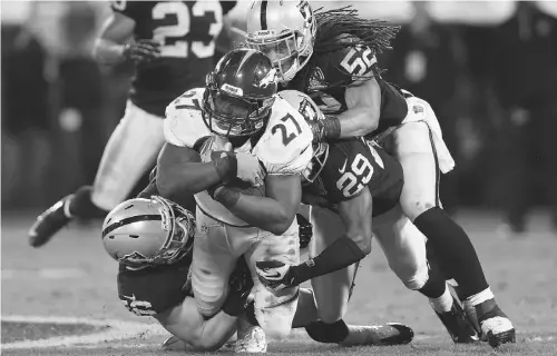  ?? EZRA SHAW/ GETTY IMAGES ?? Denver’s Knowshon Moreno is tackled by the Raiders’ Philip Wheeler and Brandian Ross in Oakland, Calif., on Thursday night.