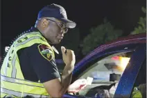  ?? Associated Press photo ?? In this May 2016 photo, Officer James Smallwood with the Jacksonvil­le Police Department speaks with a driver at a checkpoint in Jacksonvil­le, N.C.