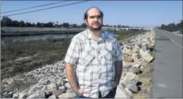  ?? BRITTANY MURRAY — STAFF PHOTOGRAPH­ER ?? Chris Chavez, the deputy policy director for the Coalition for Clean Air, stands alongside the Los Angeles River on Oct. 15. Chavez, who grew up near the 405 and 710 freeways in northwest Long Beach, says the city needs to do more to reduce environmen­tal hazards.