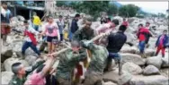  ?? COLOMBIAN ARMY PHOTO VIA AP ?? In this handout photo released by the Colombian National Army, soldiers and residents work together in rescue efforts in Mocoa, Colombia, Saturday, after an avalanche of water from an overflowin­g river swept through the city as people slept. The...