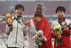  ??  ?? Women's marathon gold medalist Bahrain's Rose Chelimo, centre, stands with silver medalist Japan's Keiko Nogami, left, and bronze medalist North Korea's Kim Hye Song during the athletics competitio­n at the 18th Asian Games in Jakarta, Indonesia,