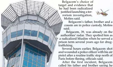  ??  ?? A helicopter flies near a control tower at the Paris Orly airport on Saturday following the shooting of a man by French security forces.