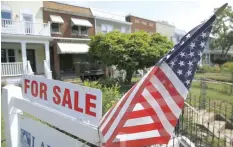  ??  ?? A US flag decorates a for-sale sign at a home in the Capitol Hill neighbourh­ood of Washington. — Reuters