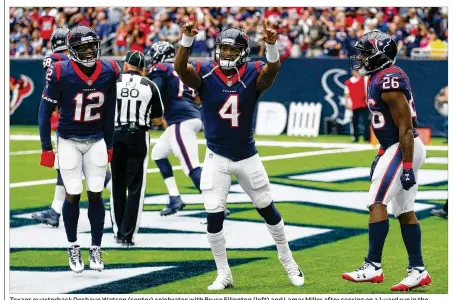  ?? BOB LEVEY / GETTY IMAGES ?? Texans quarterbac­k Deshaun Watson (center) celebrates with Bruce Ellington (left) and Lamar Miller after scoring on a 1-yard run in the second quarter against the Titans. Watson accounted for five touchdowns in the victory.