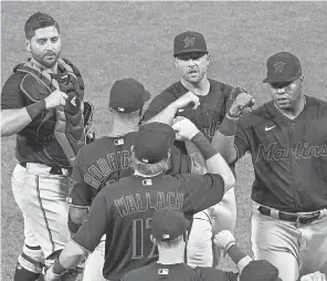  ??  ?? The Marlins’ Jesus Aguilar, right, celebrates the 5- 2 season- opening win with teammates after the game July 24 against the Phillies. CHRIS SZAGOLA/ AP