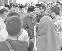  ??  ?? Musa (centre) greeting visitors attending the open house at the Kota Kinabalu Sports Complex in Likas. — Bernama photo