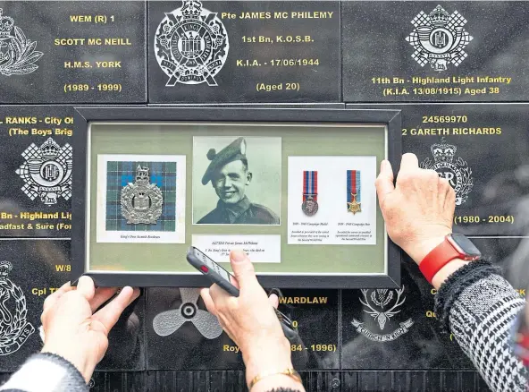  ?? ?? Relatives of Private James Mcphilemy hold up his photo and medals at the plaque at Glasgow Central Station. Above, Sergeant John Hannah’s daughters Jacqueline Eckles, Jo Burdit and Jenny Newman