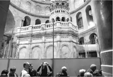  ??  ?? A visitor photograph­s the newly restored Edicule, the ancient structure housing the tomb, which according to Christian belief is where Jesus’ body was anointed and buried, at the Church of the Holy Sepulchre in Jerusalem’s Old City. — Reuters photo