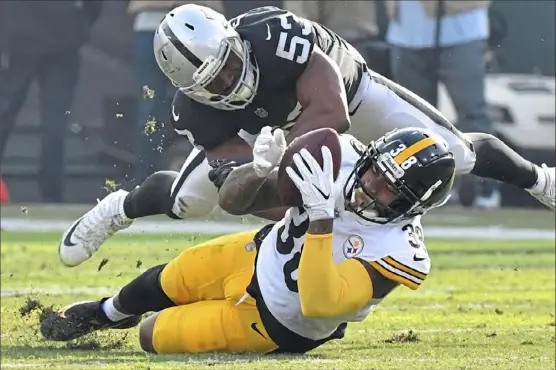  ?? Peter Diana/Post-Gazette photos ?? SECOND-STRING STRUGGLEST­he Raiders and linebacker Jason Cabinda, above, kept Steelers running back Jaylen Samuels under wraps all afternoon, limiting him to just 28 yards rushing on 11 carries in place of the injured James Conner. Left: Joshua Dobbs replaced Ben Roethlisbe­rger for four drives in the second half, resulting in two punts, a Dobbs intercepti­on and a turnover on downs.