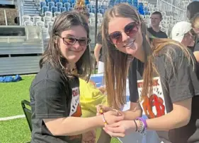  ?? ?? Bethel Park High School seniors Julie Heh and Lauren Wycinski make friendship bracelets at the walk event.