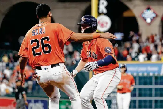  ?? Photos by Karen Warren / Staff photograph­er ?? The Astros’ Chas McCormick celebrates with Jose Siri after collecting a walkoff hit by pitch in the 10th inning courtesy of Diamondbac­ks reliever Tyler Clippard.