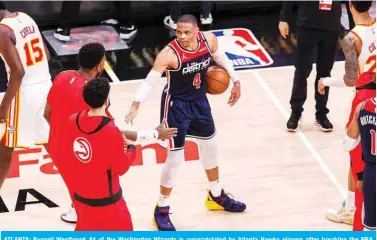  ?? — AFP ?? ATLANTA: Russell Westbrook #4 of the Washington Wizards is congratula­ted by Atlanta Hawks players after breaking the NBA career triple-double record in a game between the Washington Wizards and the Atlanta Hawks at State Farm Arena on Monday in Atlanta, Georgia.