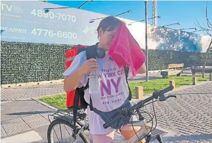  ?? ?? Líquido y toalla. El kit indispensa­ble que lleva Camila Sifuentes (22) para trabajar en bici con la ola de calor.