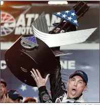  ?? AP/JOHN BAZEMORE ?? Kevin Harvick
hoists the trophy after winning the NASCAR Monster Energy Cup Series race Sunday at Atlanta Motor Speedway in Hampton, Ga.
