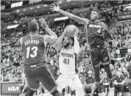  ?? D.A. VARELA dvarela@miamiheral­d.com ?? Heat center Bam Adebayo and forward Victor Oladipo defend against Pistons forward Saddiq Bey during their game on Dec. 6.