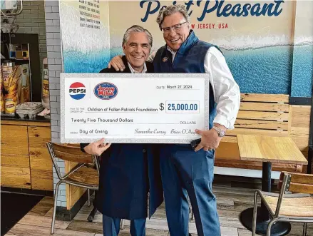  ?? Rob DeRosa/Contribute­d photo ?? Greenwich resident Joe Cabrera, left, and Brian O’Hagan, owner of Jersey Mike’s Subs in Riverside, hold a charitable donation on the sub shop’s “Day of Giving” on Wednesday. The donation is going to the Children of Fallen Patriots Foundation.